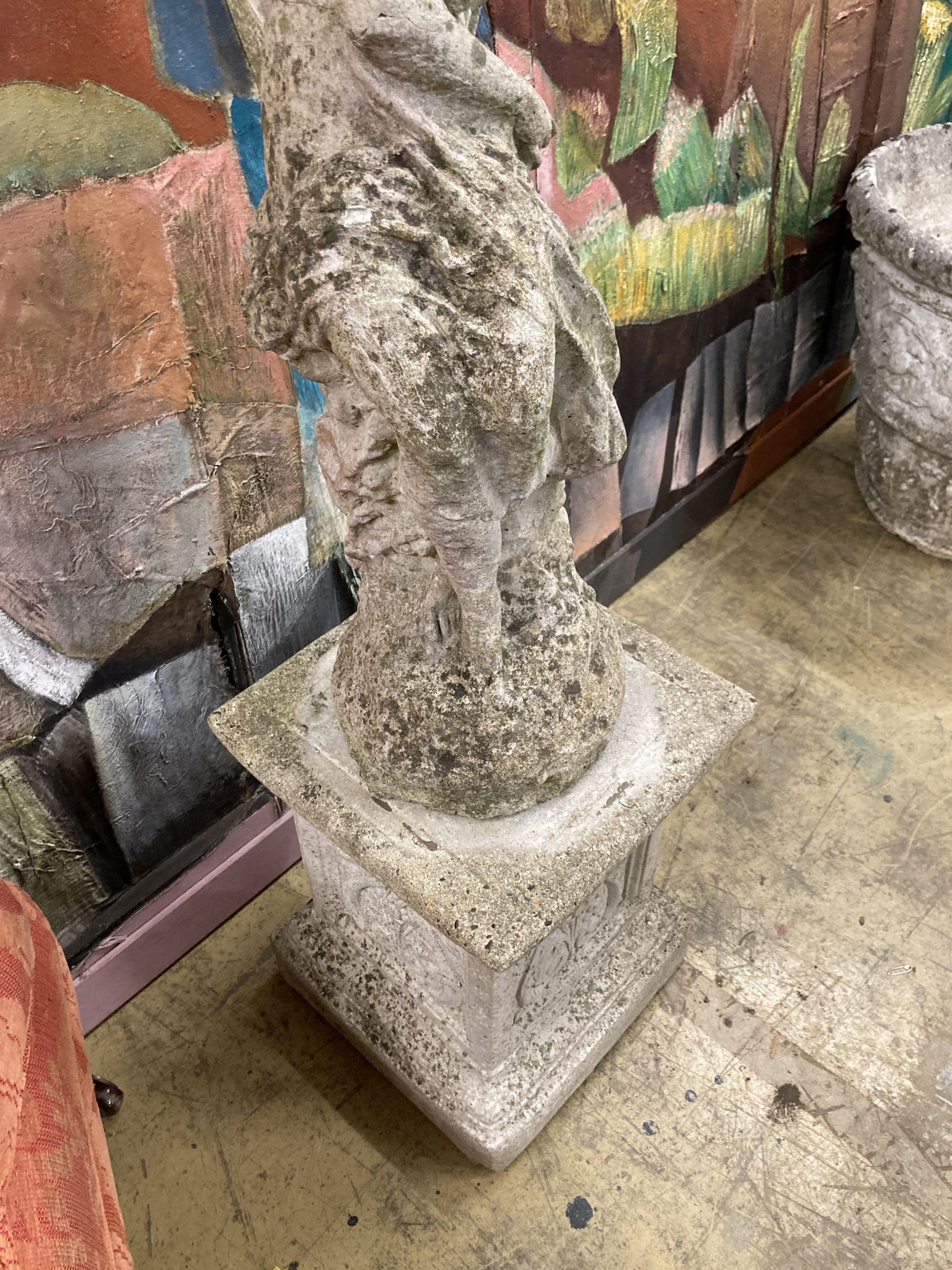 Two reconstituted stone figural garden ornaments on stands, larger 128cm high